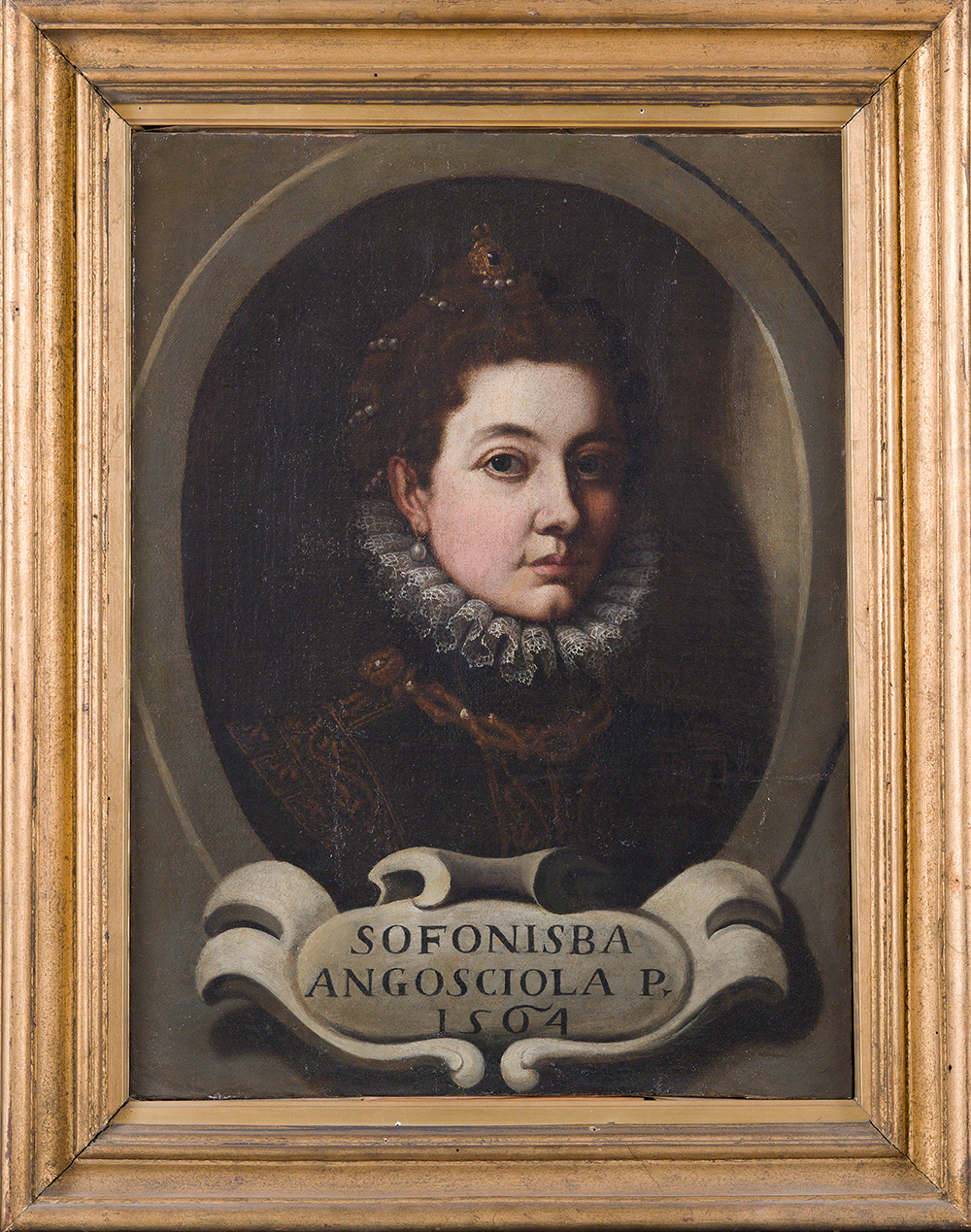 A painting shows a woman from the bust up, gazing directly at the viewer. She wears pearl earrings and an elaborate headband adorned with pearls and topped by a small tiara. Her figure is set within a medallion-like frame that appears inside the larger frame of the image. A cartouche is inscribed with “Sofonisba Angosciola P. 1564.”